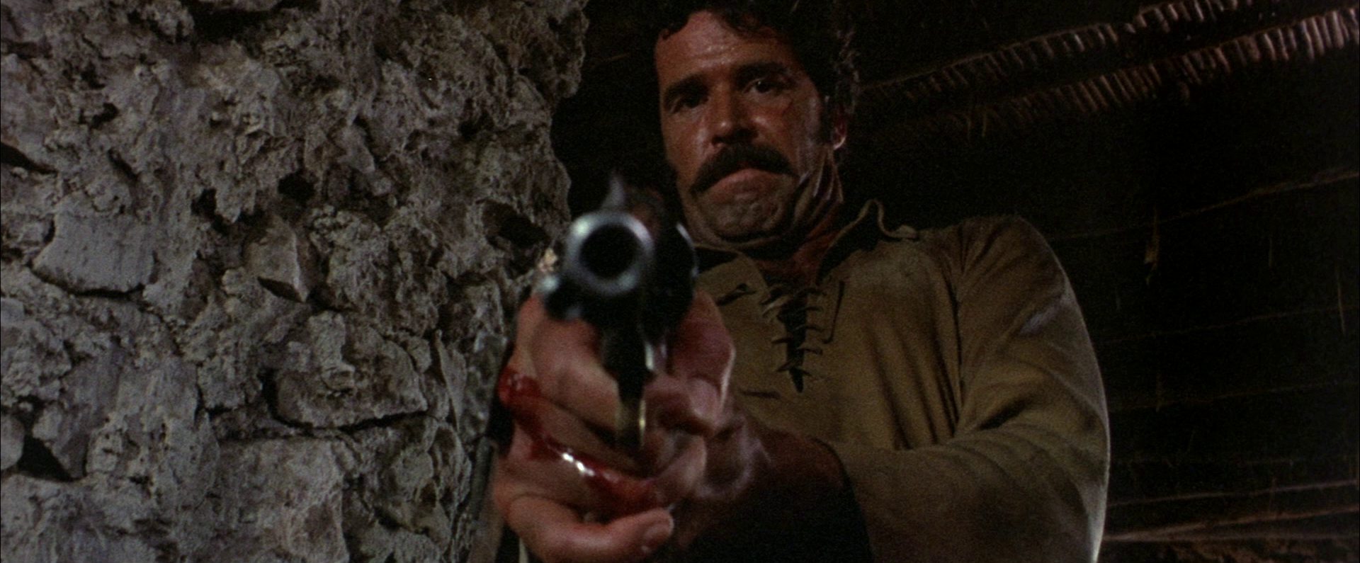 Blick in den Lauf des Revolvers, den ein ramponierter James Garner als Luther Sledge in die Kamera hält.