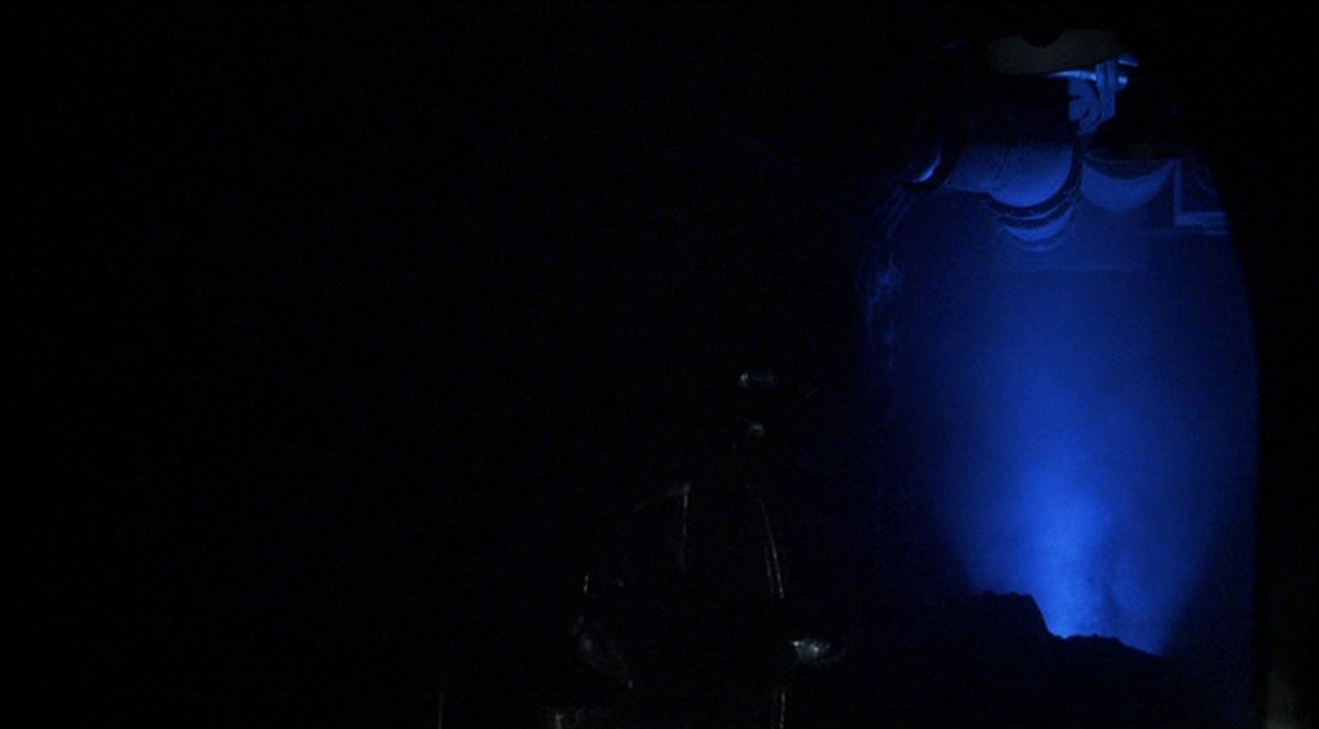 Blick in einen blau ausgeleuchten Teil eines dunklen U-Bootes in mysteriöser Atmosphäre.