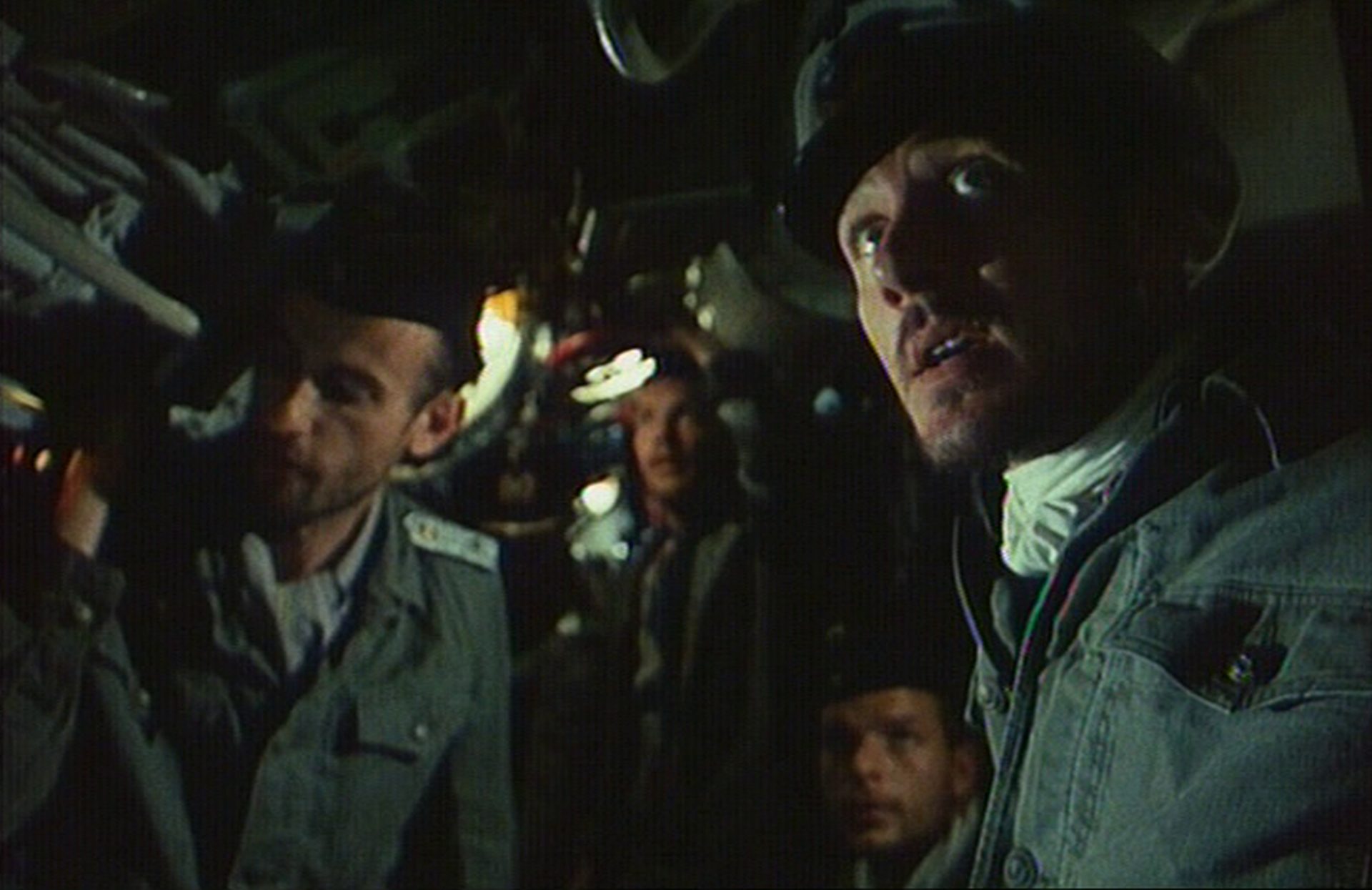 Blick in ein deutsches U-Boot, am rechten Rand Ulrich Mühe als Kommandant mit weit aufgerissenen Augen.