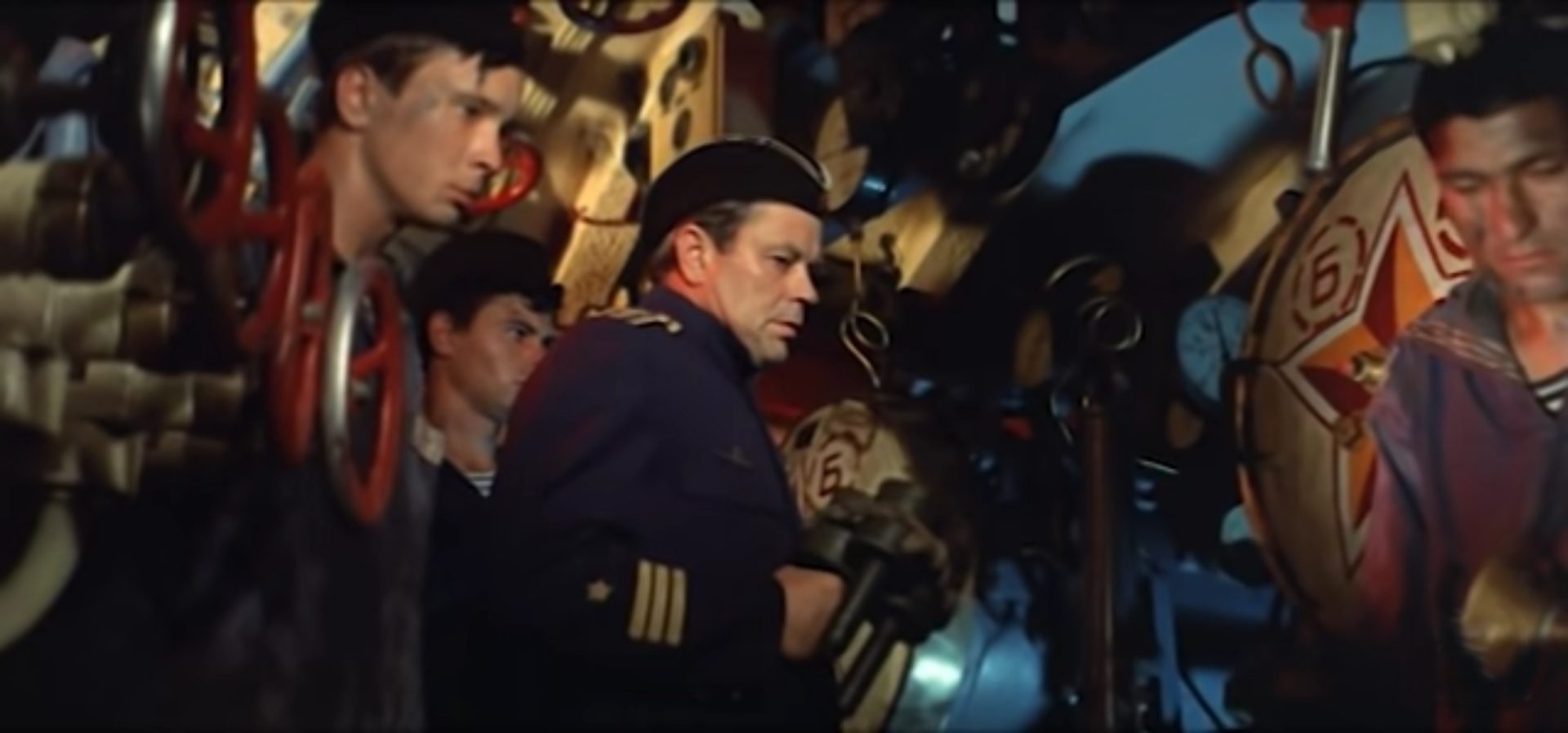 Soviet submarine pilots in the torpedo room in a tense atmosphere, filmed from a low angle view.