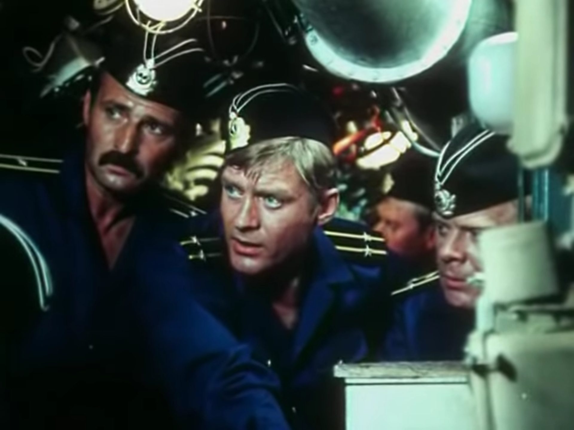 Nahaufnahme von drei sojwetischen U-Boot-Fahrern mit besorgten Blicken in beengter Atmosphäre.