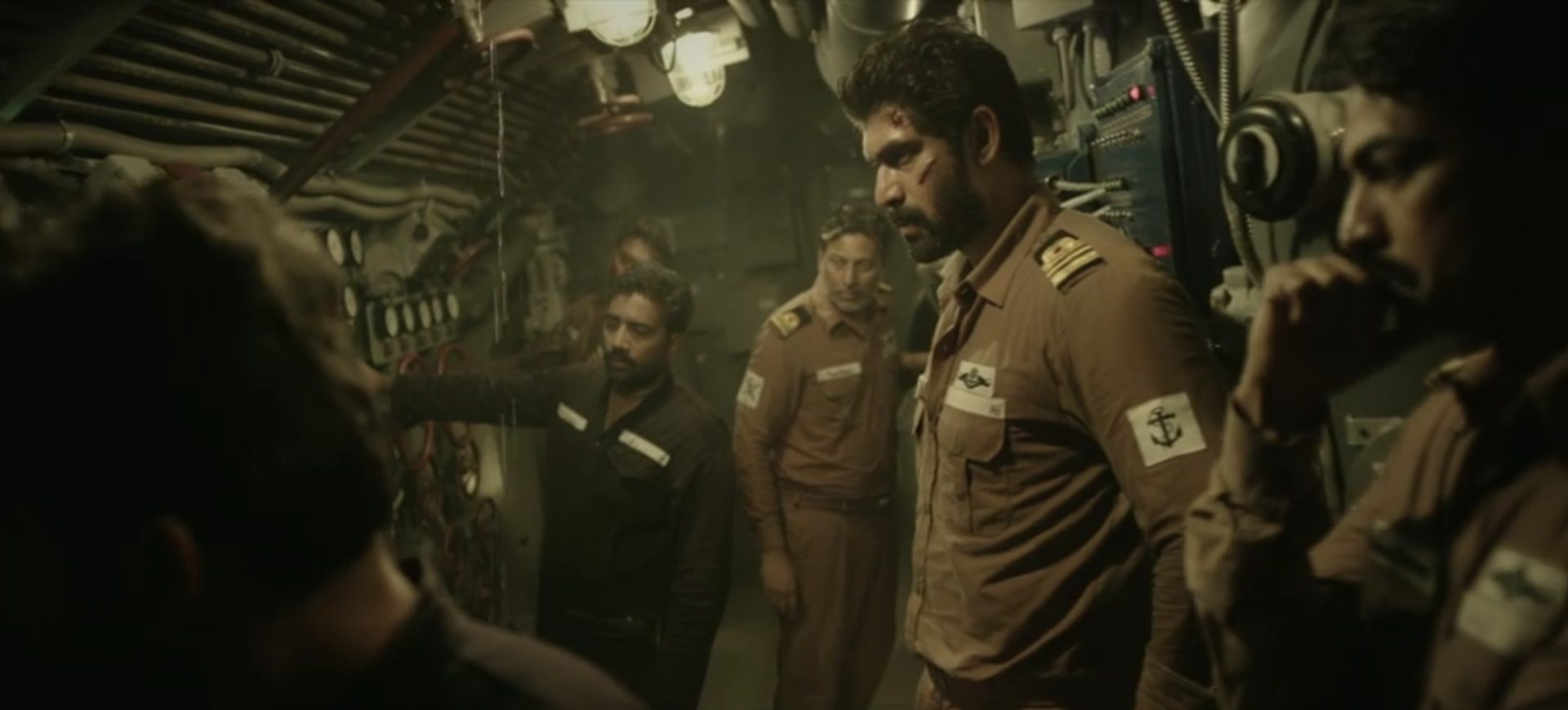 Rana Daggubati als U-Boot-Kommandant mit leicht verwundetem Gesicht in angespannter Atmosphäre.