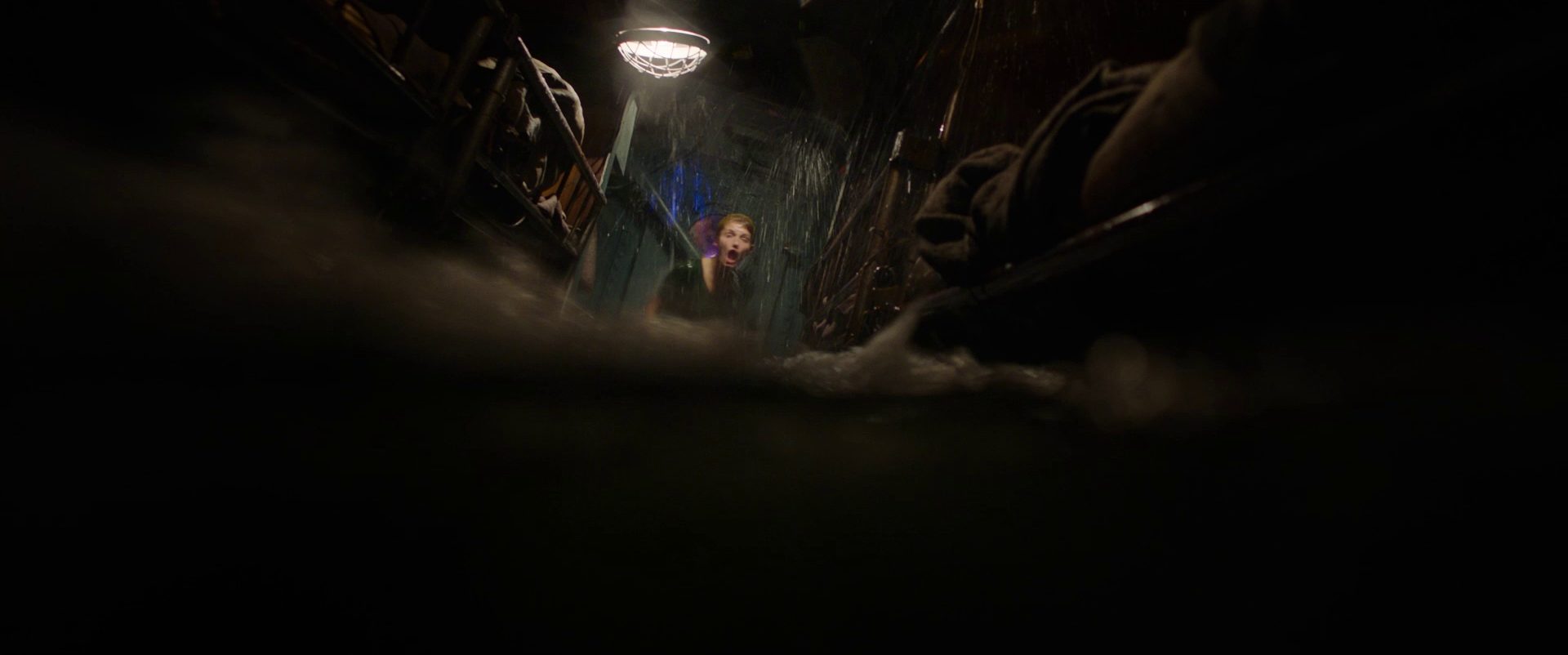 Halb-unter-Wasser-Blick durch ein volllaufendes U-Boot-Abteil, an dessen Ende eine schreiende Frau in Angst halb aus dem Wasser ragt.