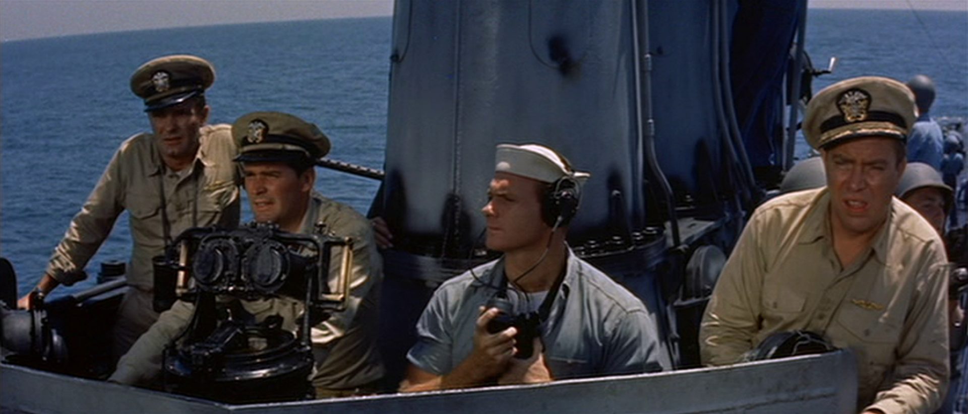 Vier konzentrierte Seeleute im Ausguck eines aufgetauchten Navy-U-Bootes.