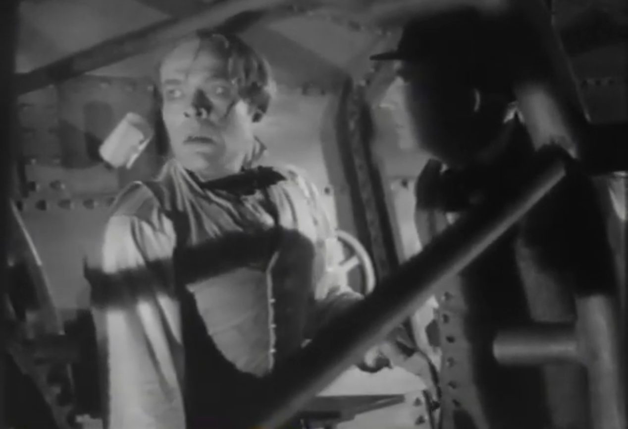 Schwarz-Weiß-Szene mit Alexander Golling als Wilhelm Bauer in abgekämpfter Pose in seinem Tauchboot, neben ihm ein Assistent im Dunkel eines Schattens.