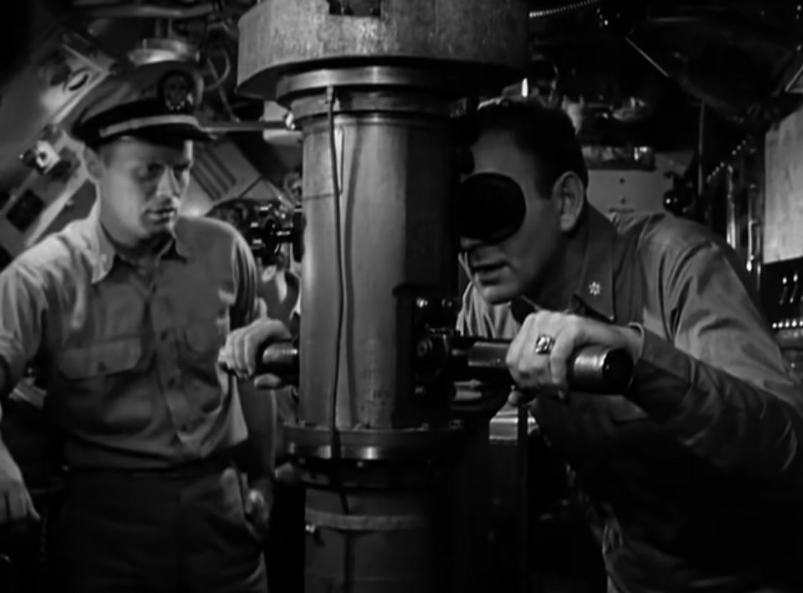 Schwarz-Weiß-Szene mit Richard Widmark links im Bild; rechts im Bild der U-Boot-Kapitän beim Blick durch das Sehrohr.