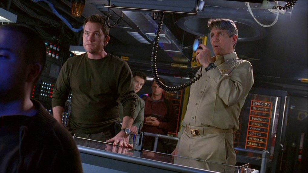 Szene in der U-Boot-Zentrale: Maury Sterling als Kidnapper in Zivilkleidung, neben ihm Eric Roberts als Kommandant in Navy-Uniform mit dem verkabelten Sprechgerät in der Hand.