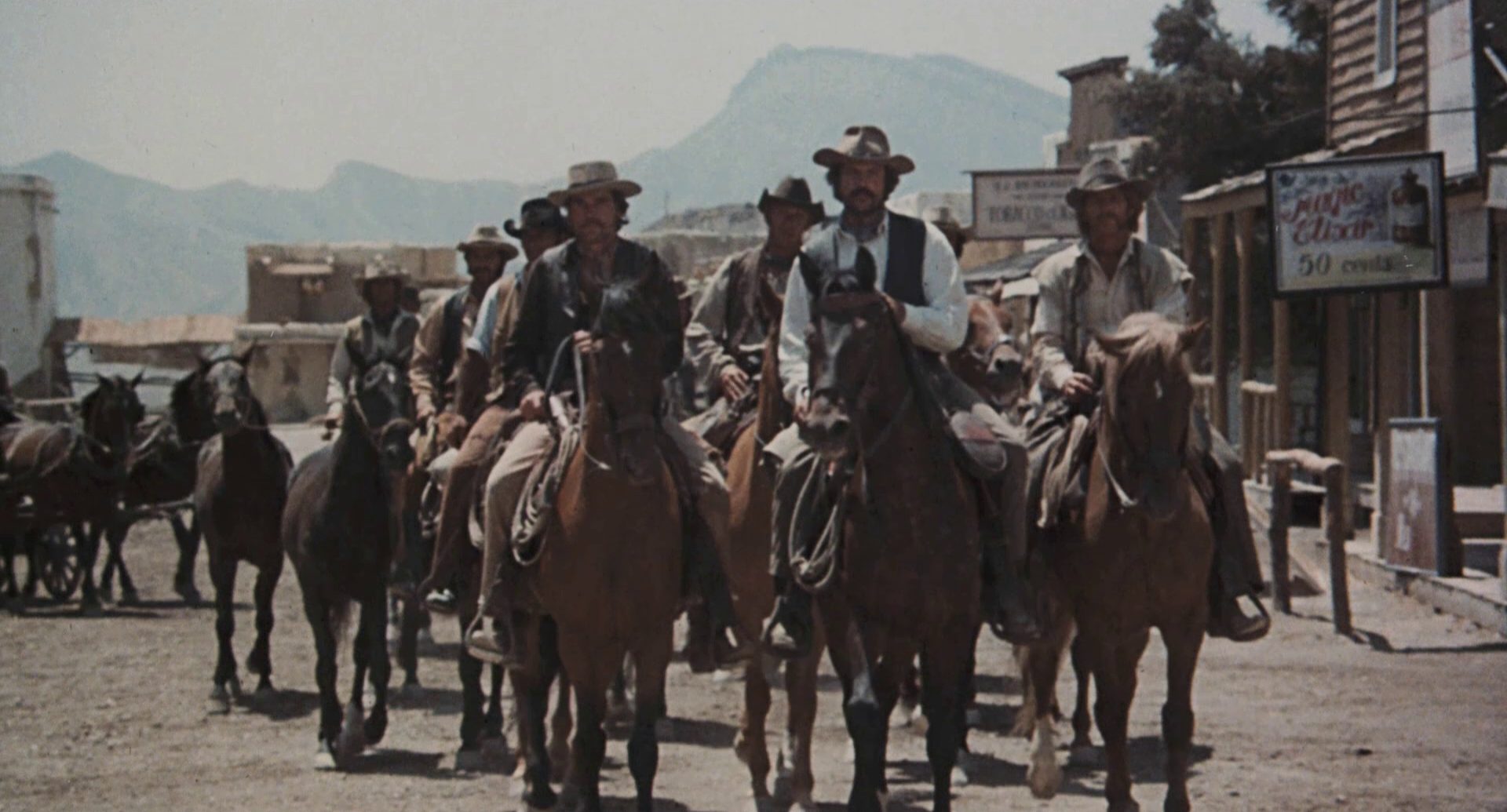 A troop of bandits on horseback in a small town.
