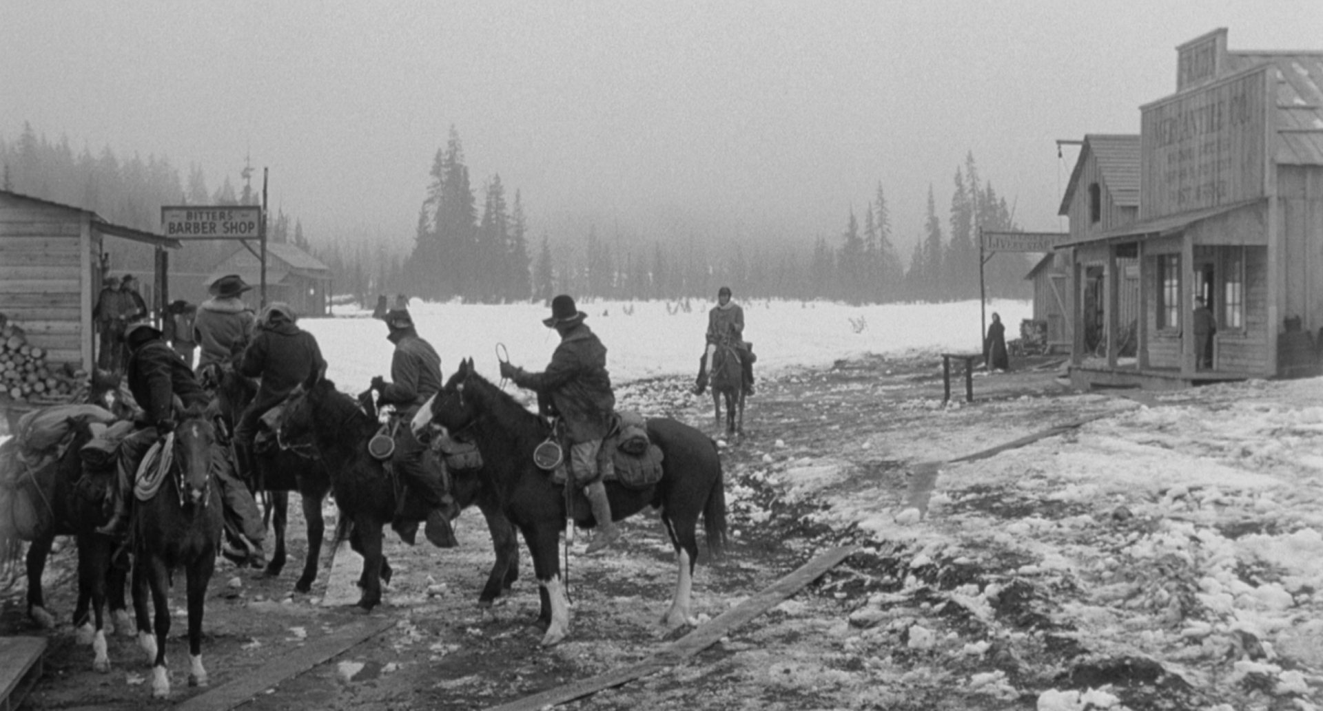 View into the slush-covered street of a tiny village; in the foreground are some riders on horseback waiting, in the background an endless wilderness is hinted at.