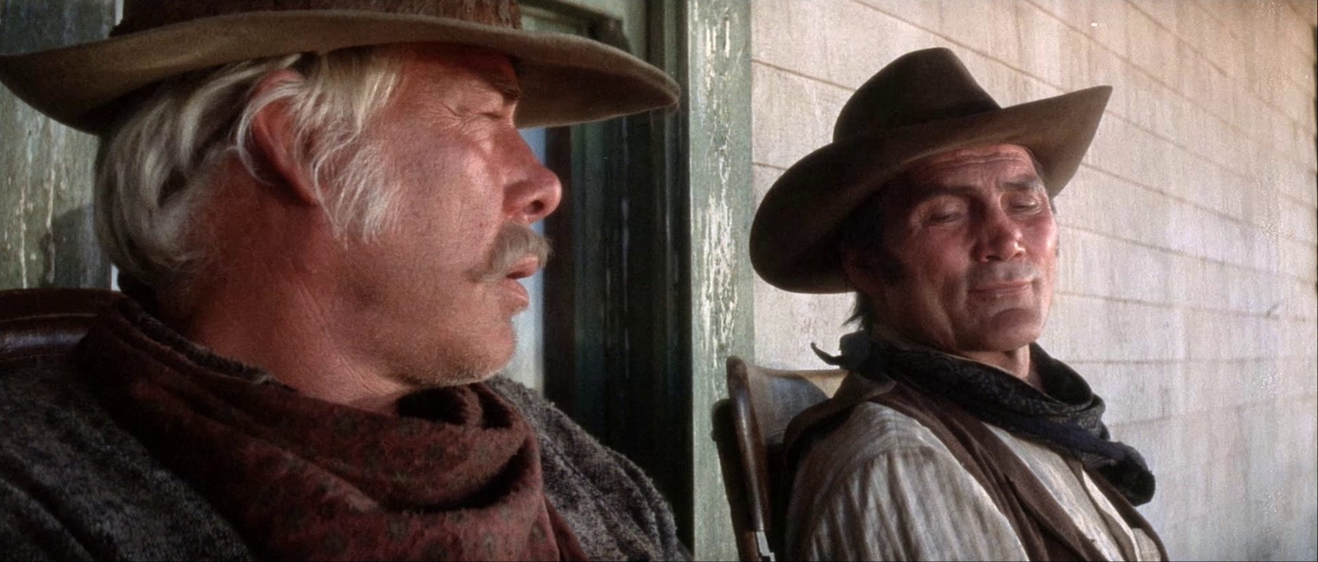 Close-up of Lee Marvin as Monte Walsh and Jack Palance as Chet Rollins sitting in chairs on a porch.