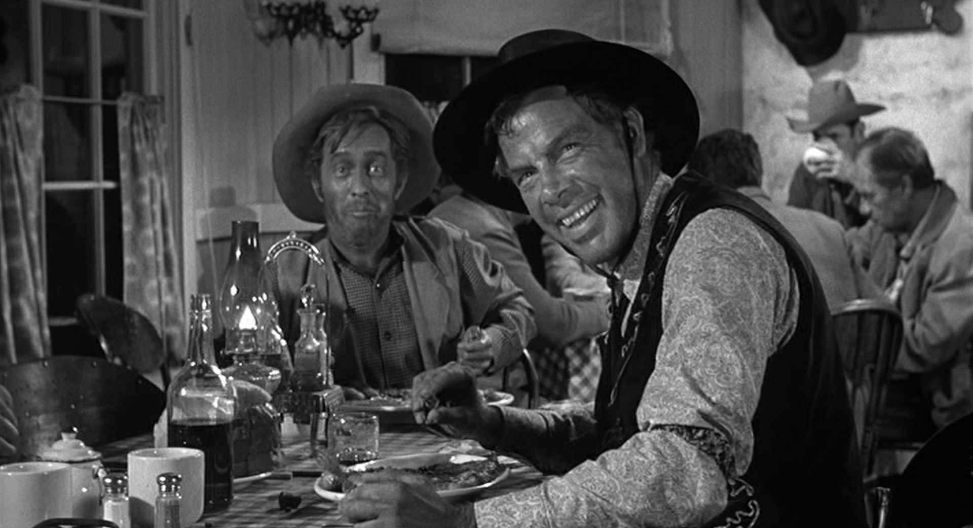 Die grinsende Visage von Liberty Valance am Esstisch eines Diners, gespielt von Lee Marvin.