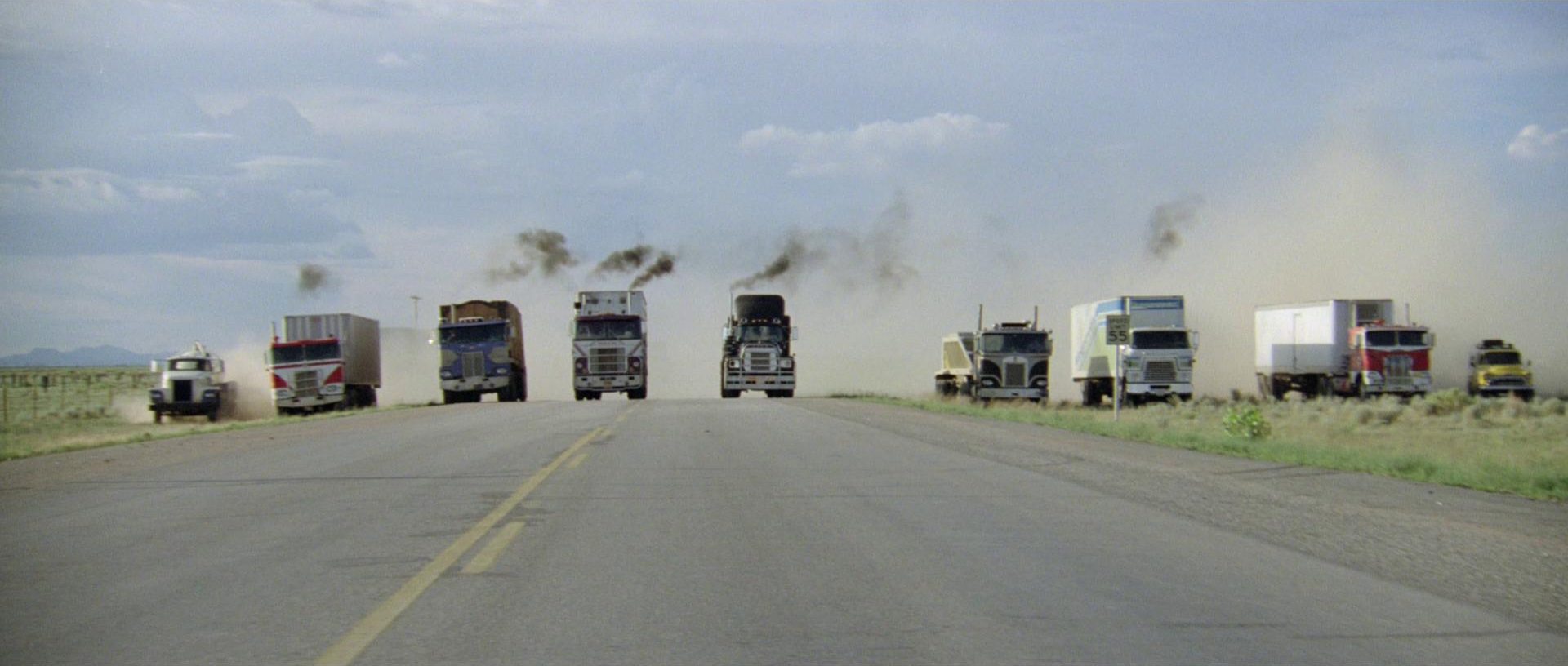 Frontalaufnahme von parallel fahrenden Trucks am Highway-Horizont.