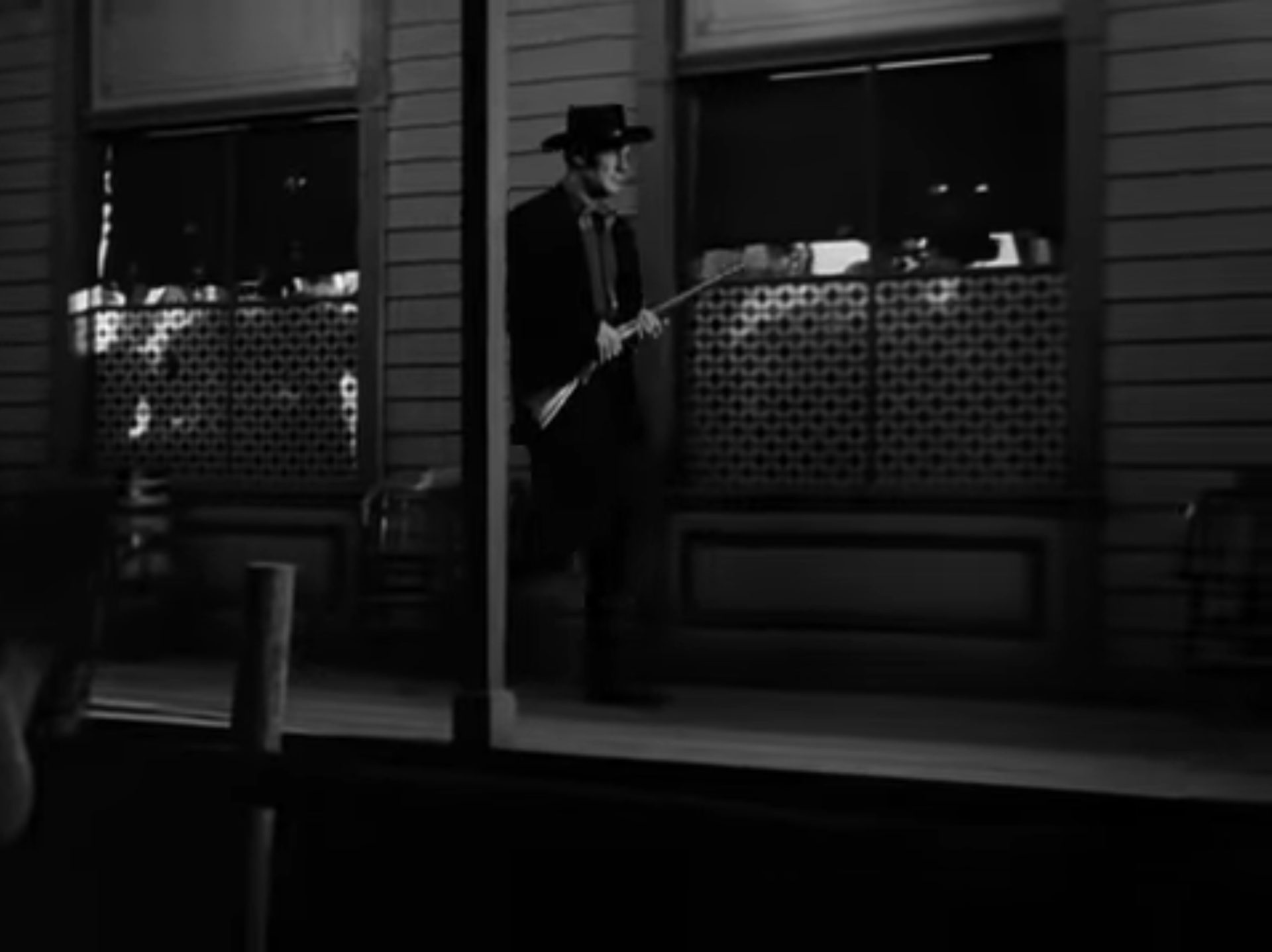 Wyatt Earp mit Gewehr im Anschlag unterwegs zum O.K. Corral in finsterem Licht.