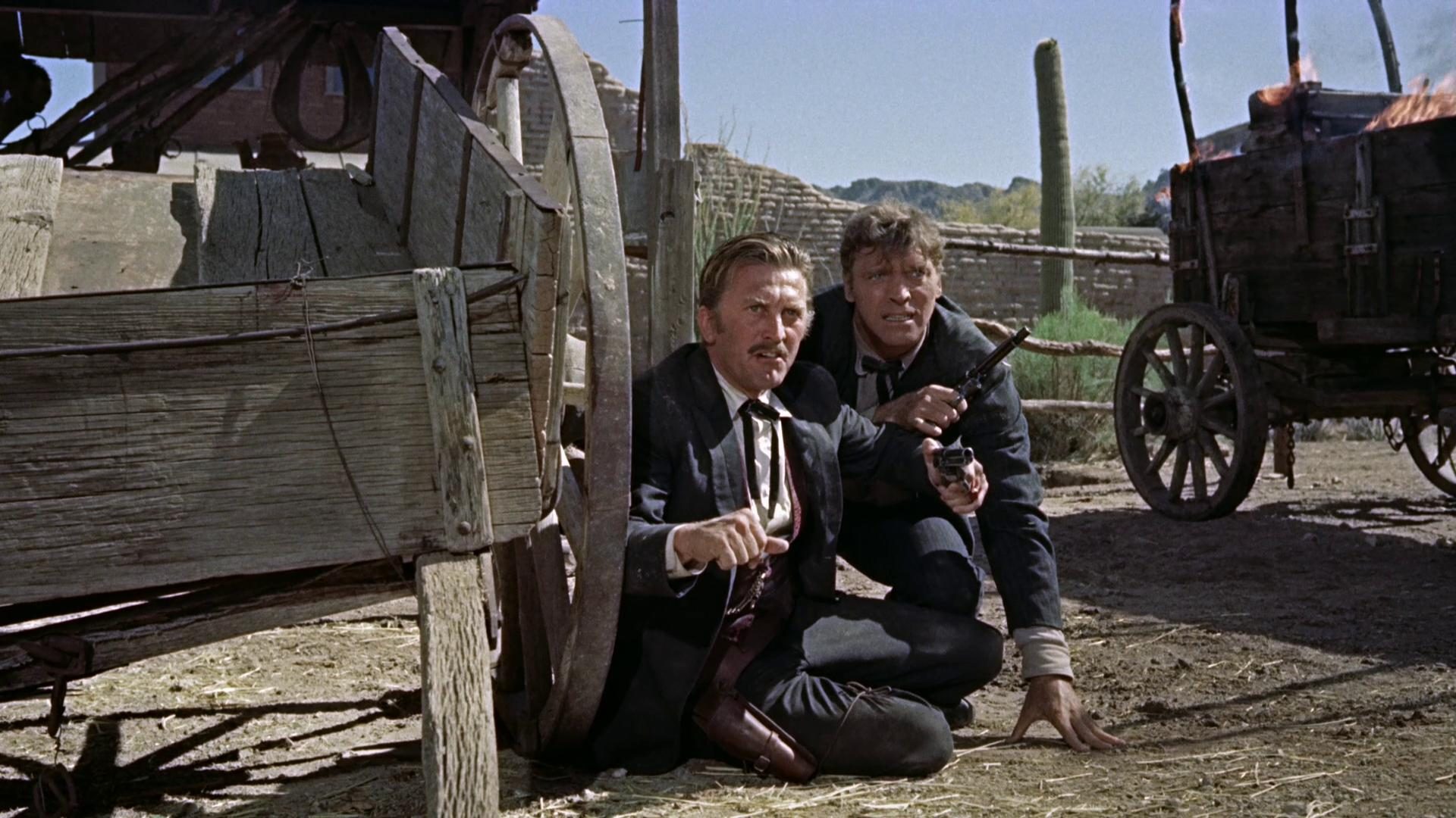 Nahaufnahme von Doc Holliday und Wyatt Earp im Schutz eines Wagenrades während der Schießerei am „O.K. Corral“.