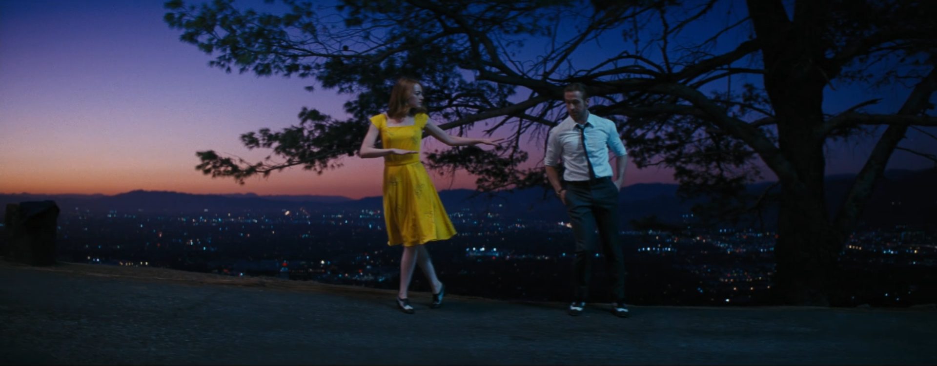 Emma Stone als Schauspielerin Mia und Ryan Gosling als Musiker Sebastian tanzen in der kalifornischen Abenddämmerung, im Hintergrund breitet sich im Tal das nächtlich erleuchtete Los Angeles aus.