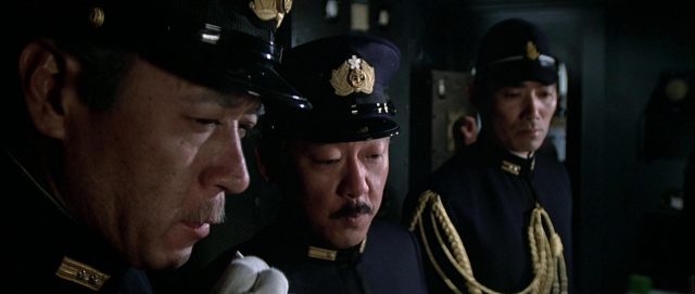 Close-up dreier japanischer Offiziere mit konzentrierten Gesichtern.