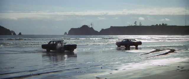Zwei Fahrzeuge in der Anordnung eines Shootouts am Küstenstrand.