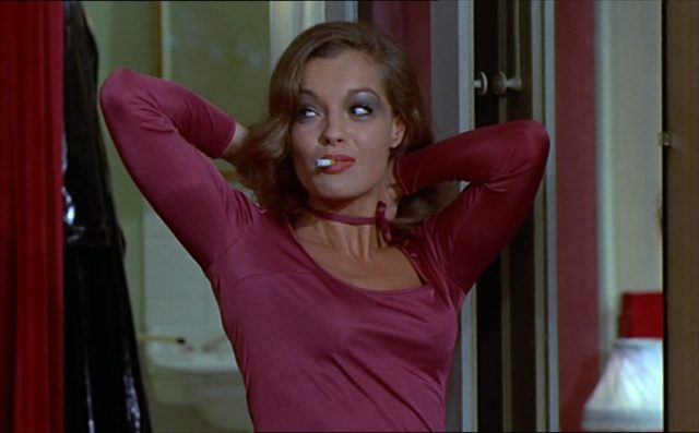 Romy Schneider als auffällig geschminkte Prostituierte Lily mit einer Zigarette.