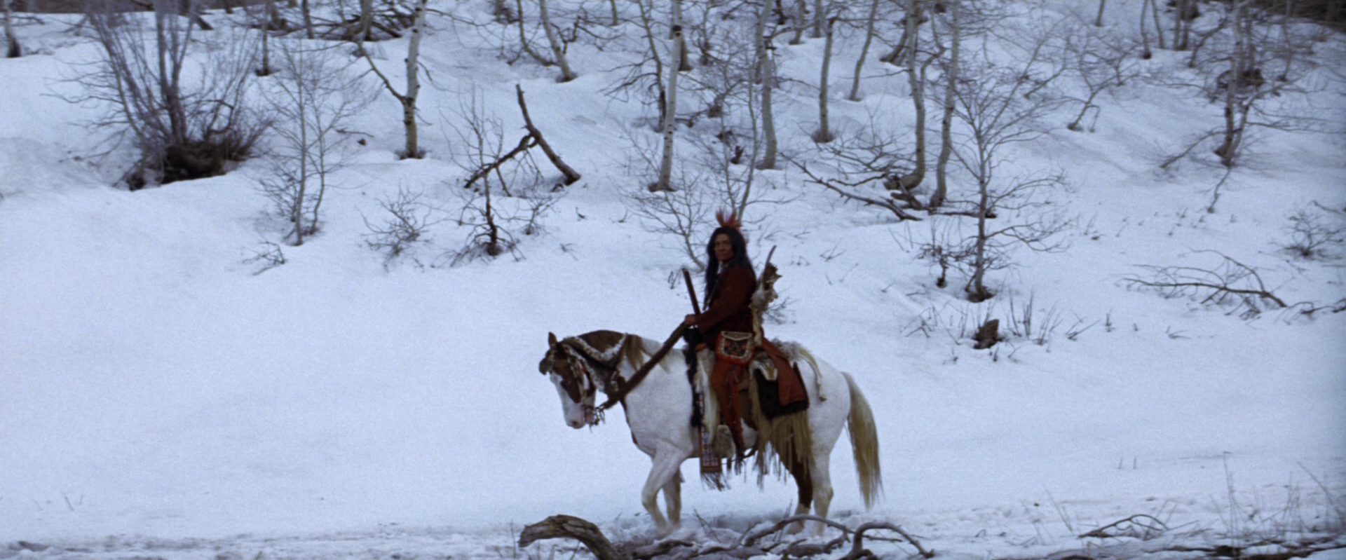Indianer zu Pferd in unwirtlicher Schneelandschaft.