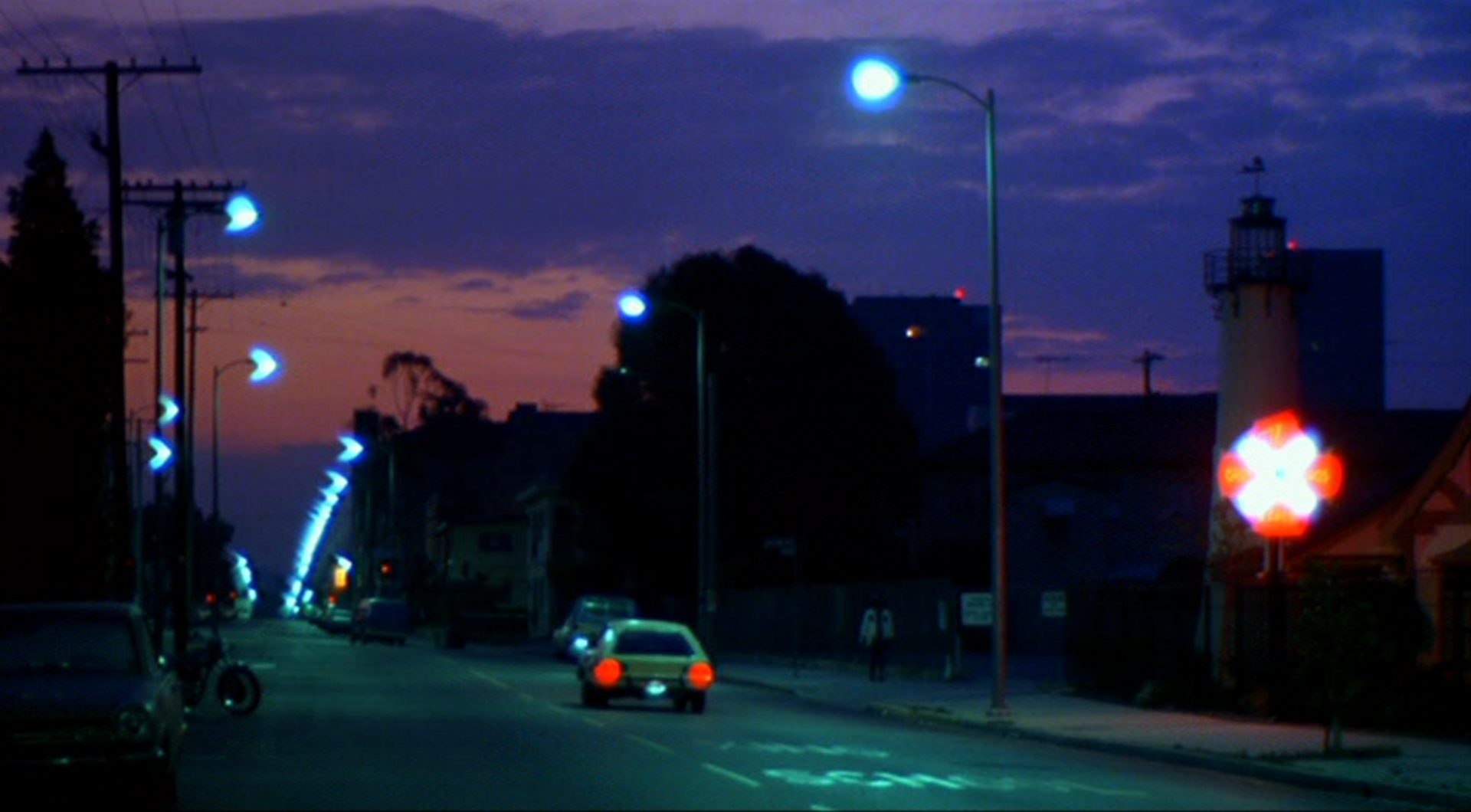Nachtaufnahme eines Straßenzuges mit hellen Laternen.