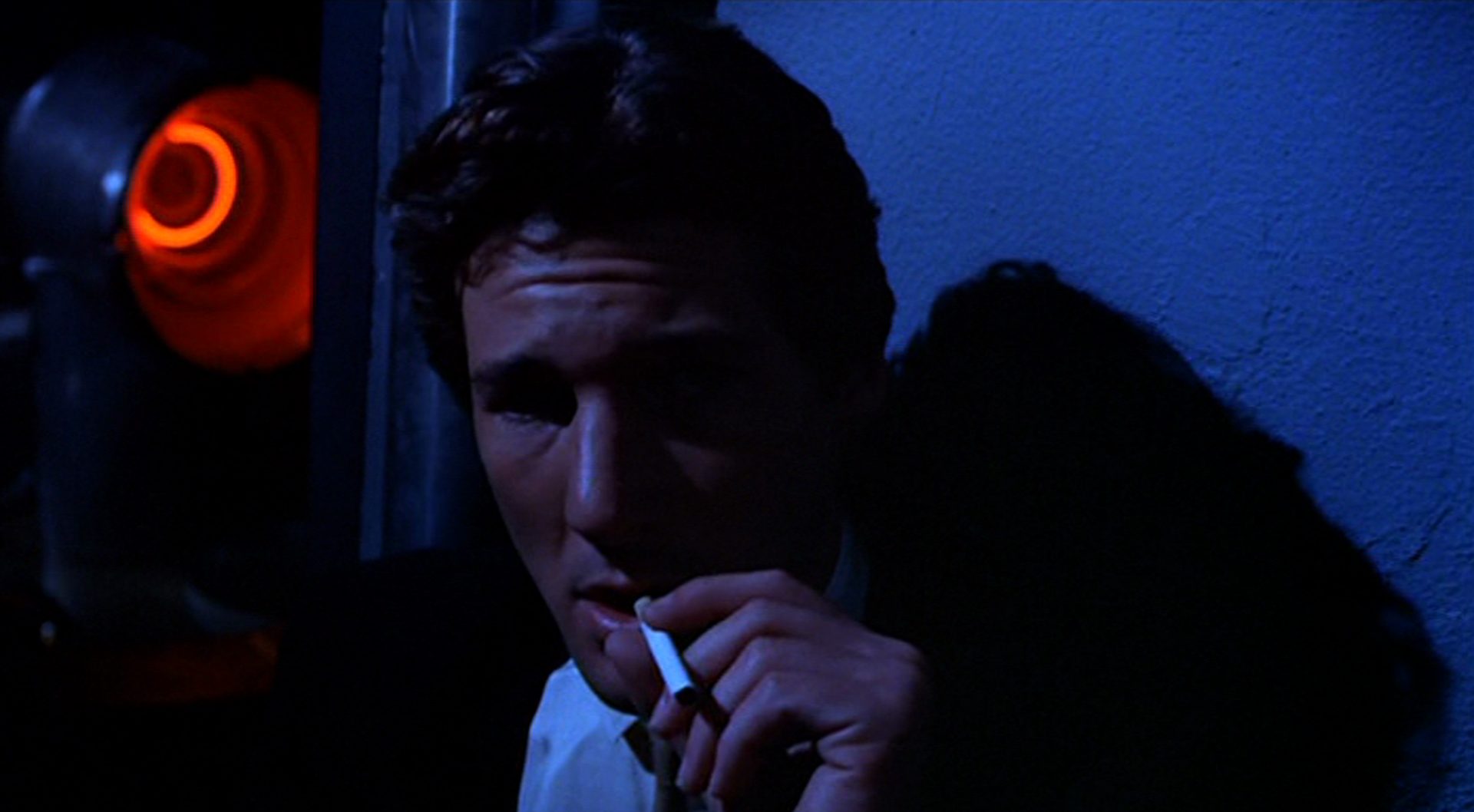Nahaufnahme von Richard Gere als Julian Kaye mit Zigarette in nächtlichem Ambiente.