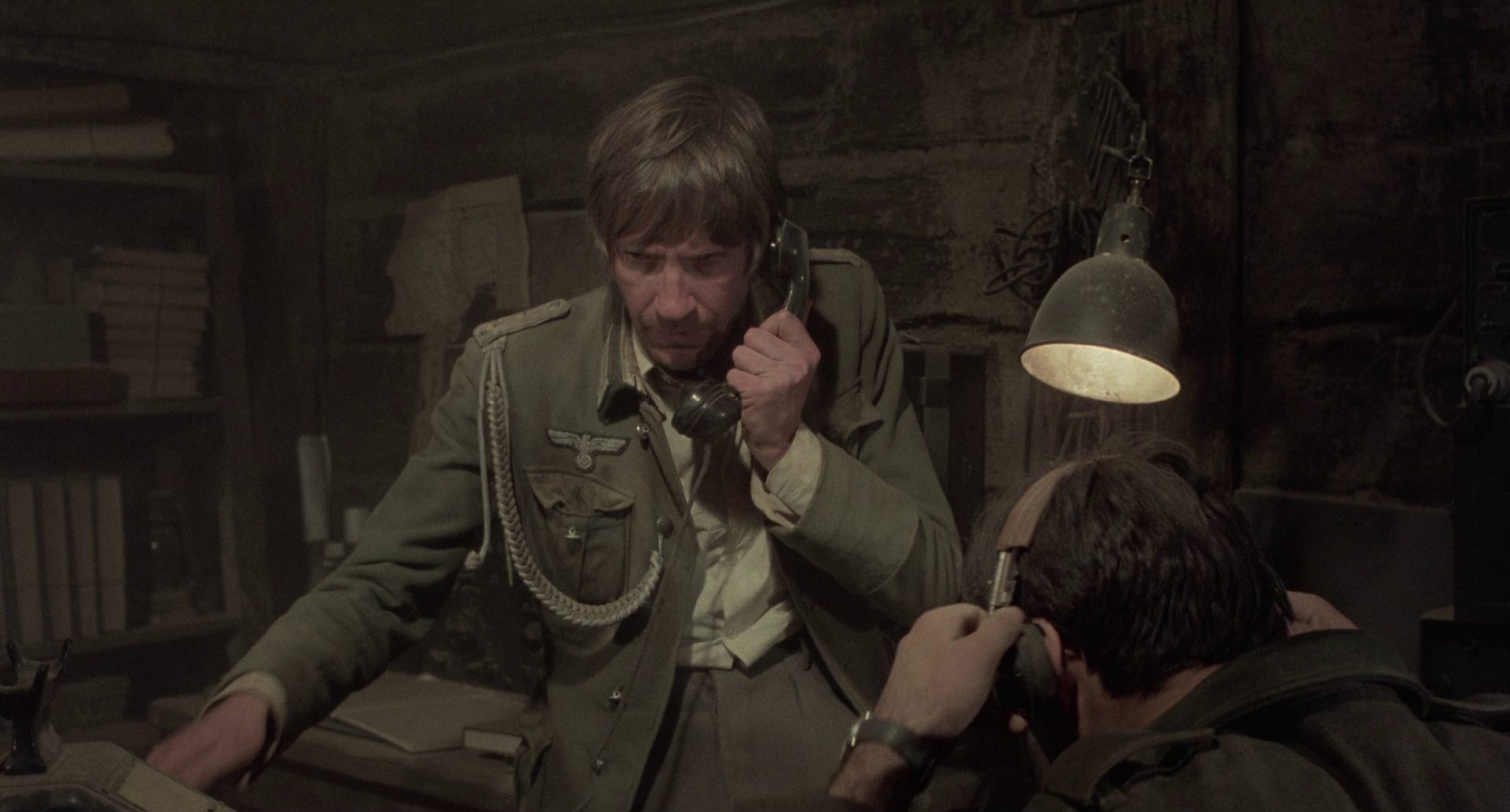 David Warner als Stabsoffizier Kiesel am Telefon im Unterstand.