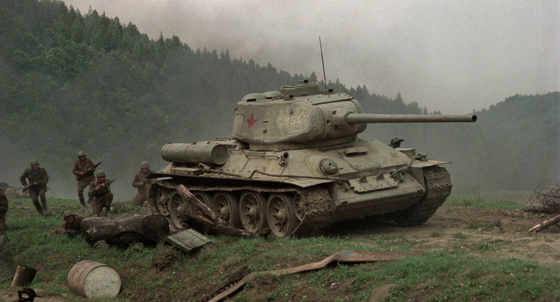 Rotarmisten nähern sich auf dem Schlachtfeld im Schutz eines T-34-Panzers.